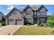 Beautiful two-story brick home with a well-manicured lawn and attached two-car garage at 7575 Old Camp Lndg, Cumming, GA 30040