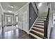 Traditional foyer with wood floors, white wainscoting, and a staircase with a dark wood railing at 7575 Old Camp Lndg, Cumming, GA 30040
