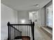 Second floor hallway with neutral walls, carpeted floors, dark wood railing, and white trim at 7575 Old Camp Lndg, Cumming, GA 30040