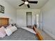 This light and bright main bedroom has an en suite bathroom, ceiling fan, and neutral tones throughout at 7575 Old Camp Lndg, Cumming, GA 30040