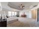 Spacious primary bedroom boasts a trey ceiling, plush carpet, and a private ensuite bathroom at 7575 Old Camp Lndg, Cumming, GA 30040