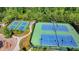Aerial view of tennis courts in a wooded community with landscaping and benches at 7575 Old Camp Lndg, Cumming, GA 30040