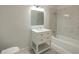Bright bathroom featuring a tub and shower combination with white marble-look tiles and a white vanity at 1120 Arlington Sw Ave, Atlanta, GA 30310