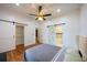 A stylish bedroom featuring hardwood floors, modern ceiling fan, sliding barn doors, and ample space at 1120 Arlington Sw Ave, Atlanta, GA 30310