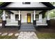 Charming home featuring a bright yellow door, covered porch, and fresh landscaping leading to the entrance at 1120 Arlington Sw Ave, Atlanta, GA 30310