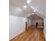 Long hallway with hardwood floors, recessed lighting, white walls, and a railing leading to stairs at 1120 Arlington Sw Ave, Atlanta, GA 30310