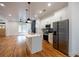 Open-concept living space with kitchen island, stainless steel appliances, hardwood floors, and natural light at 1120 Arlington Sw Ave, Atlanta, GA 30310