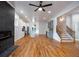 Open-concept living space with hardwood floors, a modern fireplace, kitchen, and stairs to the second level at 1120 Arlington Sw Ave, Atlanta, GA 30310