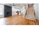 Open-concept living space with hardwood floors, a modern fireplace, kitchen, and stairs to the second level at 1120 Arlington Sw Ave, Atlanta, GA 30310