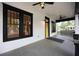 Covered front porch with black trim, yellow door, ceiling fans, and a view of the neighborhood at 1120 Arlington Sw Ave, Atlanta, GA 30310