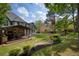 Expansive backyard featuring a covered patio, landscaped garden beds, and a lush lawn, ideal for outdoor living at 818 Forest Path Ln, Alpharetta, GA 30022