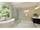 Bathroom featuring a soaking tub, a glass shower and double sink vanity with marble floors at 818 Forest Path Ln, Alpharetta, GA 30022