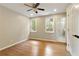 Bright bedroom featuring hardwood floors, two windows, ceiling fan, and ensuite bathroom at 818 Forest Path Ln, Alpharetta, GA 30022