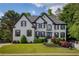 Beautiful two-story white brick home with dark shutters and a professionally landscaped lawn at 818 Forest Path Ln, Alpharetta, GA 30022