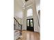 Elegant foyer featuring a hardwood floor, wrought iron staircase, and arched window above the entry door at 818 Forest Path Ln, Alpharetta, GA 30022