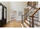 Open foyer with hardwood floors, a staircase with iron railings, and views into the adjacent office at 818 Forest Path Ln, Alpharetta, GA 30022