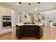 Kitchen island with gas cooktop and dark cabinets, with double ovens and an open view to the staircase and living room at 818 Forest Path Ln, Alpharetta, GA 30022