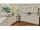 Bright kitchen with white cabinetry, stainless steel appliances, hardwood floors, and natural light from the large windows at 818 Forest Path Ln, Alpharetta, GA 30022