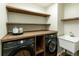 Functional laundry room with floating shelves, Samsung washer and dryer, and a sink at 818 Forest Path Ln, Alpharetta, GA 30022