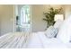 Bed with access to a luxurious bathroom with soaking tub and large arched window at 818 Forest Path Ln, Alpharetta, GA 30022