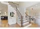 Elegant staircase with hardwood steps and iron railings leading to the upper level, open to the kitchen and living room at 818 Forest Path Ln, Alpharetta, GA 30022
