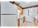 Functional kitchen with white appliances, wooden cabinets, and vintage wallpaper border near entry door at 10202 Fairington Ridge Cir, Lithonia, GA 30038