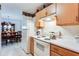 This Kitchen boasts white appliances, wooden cabinets and open view to adjacent dining room at 10202 Fairington Ridge Cir, Lithonia, GA 30038