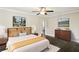 Staged main bedroom featuring dark hardwood floors, ceiling fan, and decorative artwork on the walls at 2074 Hilburn Se Dr, Atlanta, GA 30316