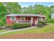 Charming red home with white trim, a cozy front porch, and well-maintained landscaping at 2900 Country Nw Ct, Kennesaw, GA 30152