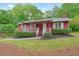 Inviting red home featuring a covered porch, neat landscaping, and a tranquil setting at 2900 Country Nw Ct, Kennesaw, GA 30152