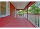 Side porch of a red home featuring painted flooring, white railings and nice view at 2900 Country Nw Ct, Kennesaw, GA 30152
