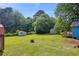 Expansive backyard features lush lawn, mature trees, and storage sheds, perfect for outdoor activities at 483 Glen Terrace Rd, Auburn, GA 30011