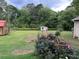 Spacious backyard with green grass, storage sheds, and flowering bushes, perfect for outdoor living at 483 Glen Terrace Rd, Auburn, GA 30011