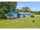Charming blue home featuring a spacious backyard, patio with seating, and mature trees at 483 Glen Terrace Rd, Auburn, GA 30011