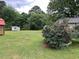 Lush backyard with mature trees, featuring a rustic shed and plenty of green space for gardening or recreation at 483 Glen Terrace Rd, Auburn, GA 30011