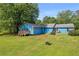 Charming blue home featuring a spacious backyard, patio with seating, and a fire pit at 483 Glen Terrace Rd, Auburn, GA 30011