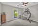 Cozy bedroom featuring a hanging chair, modern fan, and natural lighting at 483 Glen Terrace Rd, Auburn, GA 30011