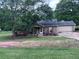 Charming single-story home with a well-maintained front yard, a large tree, and an attached two-car garage at 483 Glen Terrace Rd, Auburn, GA 30011