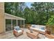 Outdoor deck featuring comfortable seating and a screened in porch overlooking a wooded area at 200 River Pass Trl, Atlanta, GA 30350
