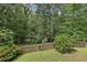 Fenced backyard with mature trees, grass, and natural landscape, offering privacy at 200 River Pass Trl, Atlanta, GA 30350