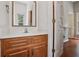 Bathroom with wood vanity, white marble countertop, mirror, and storage at 200 River Pass Trl, Atlanta, GA 30350