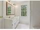 Bathroom featuring a double sink vanity, white tile floor, and window at 200 River Pass Trl, Atlanta, GA 30350
