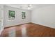 Bright bedroom featuring hardwood floors, two windows, and white walls at 200 River Pass Trl, Atlanta, GA 30350