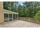 Wooden deck area attached to the sunroom, with a lattice railing and view of surrounding trees at 200 River Pass Trl, Atlanta, GA 30350