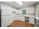 Kitchen with white cabinets, appliances, and wood floor at 200 River Pass Trl, Atlanta, GA 30350