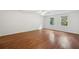 Bright main bedroom featuring hardwood floors, two windows, ceiling fan, and white walls at 200 River Pass Trl, Atlanta, GA 30350