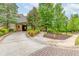 Welcoming entrance to the community club, featuring stone accents, mature trees, and manicured landscaping at 2222 Haventree Ct, Lawrenceville, GA 30043