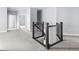 Bright hallway features neutral walls, carpeted floor, and a dark railing that overlooks stairs at 2222 Haventree Ct, Lawrenceville, GA 30043