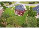 A high aerial view reveals a home's lush backyard landscaping, deck with patio furniture, and well-kept lawn at 3364 Kylee Dawn Cir, Lawrenceville, GA 30045