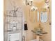 Stylish bathroom with glass bowl sink, uniquely framed mirror, and chrome storage shelf at 3364 Kylee Dawn Cir, Lawrenceville, GA 30045